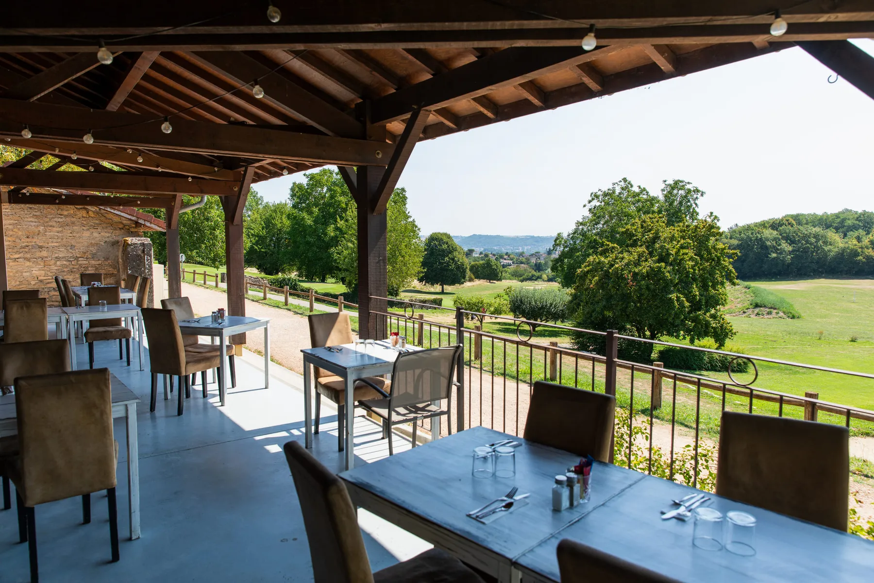 La terrasse couverte et ses tables dressées face au parcours