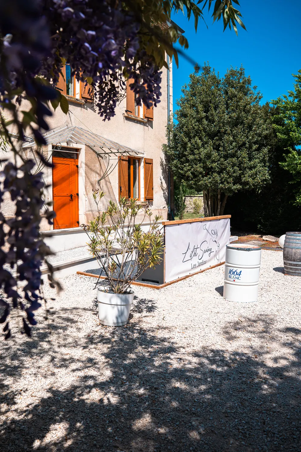 La façade de la maison vue à travers la glycine en fleur