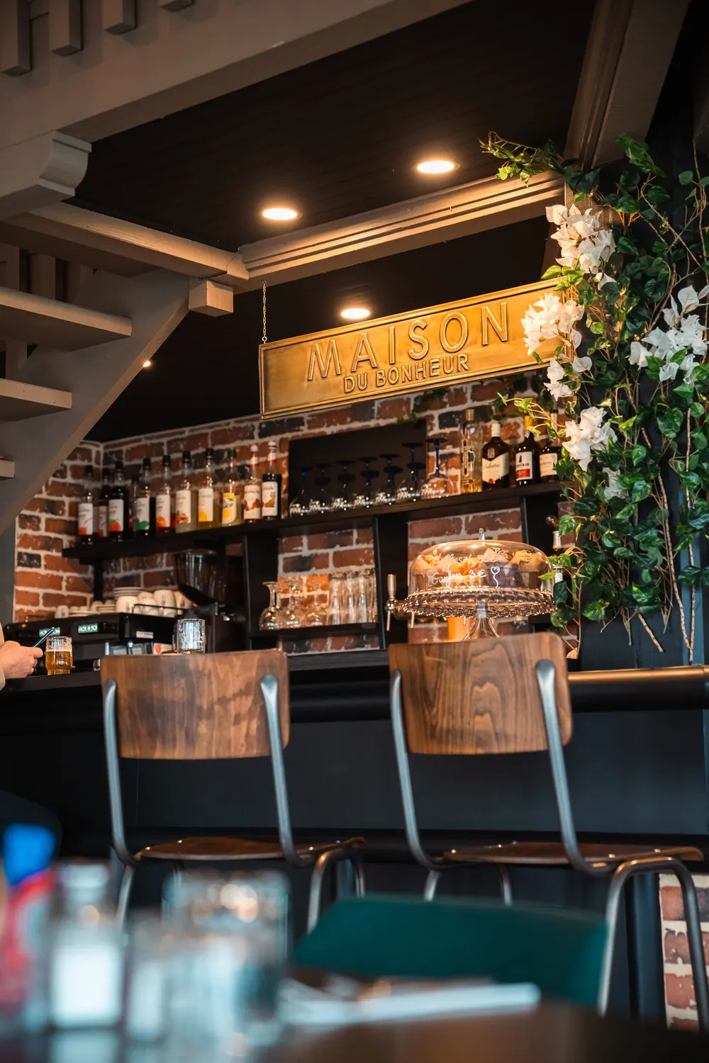 Le comptoir du bar, ses tabourets et son enseigne lumineuse